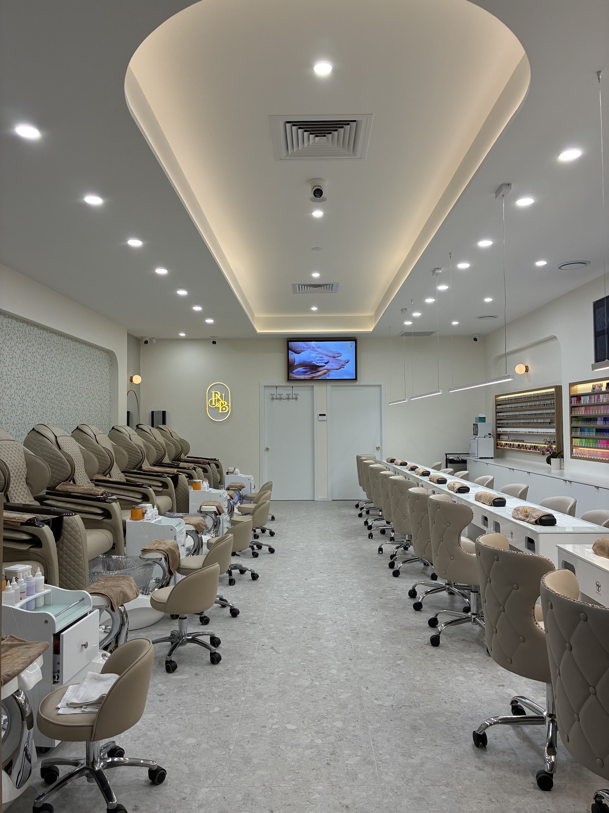 The Pro Nails & Beauty salon floor: pedicure massage chairs on one side, manicure stations and the illuminated P&B wall sign on the other