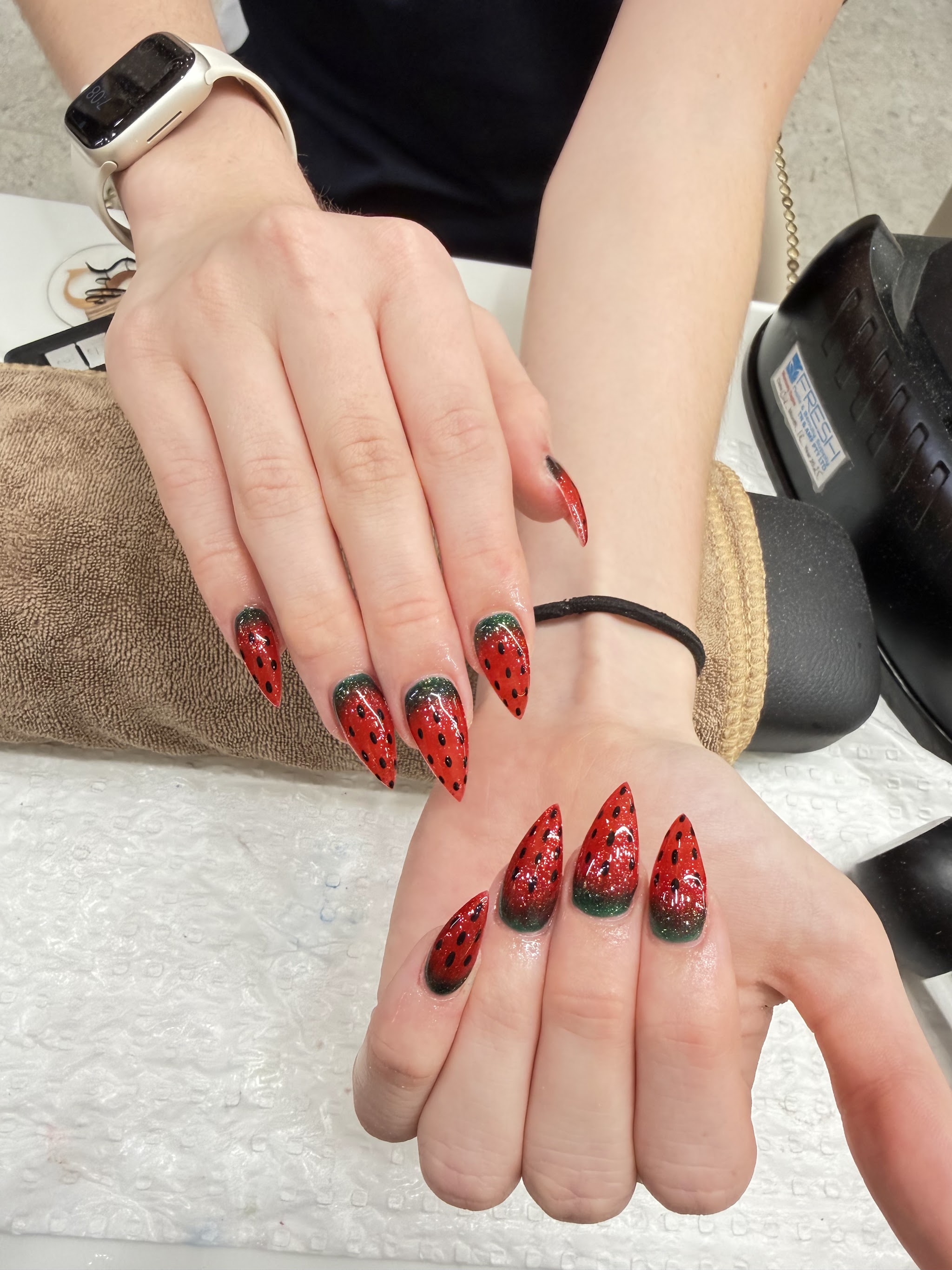 Bright watermelon inspired nail art in red, green and black on stiletto nails